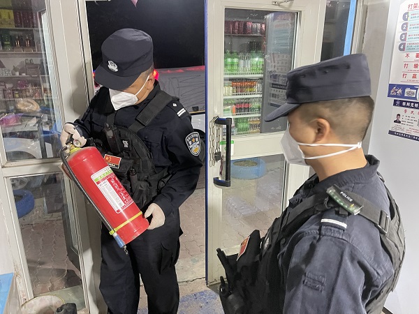 图为派出所民警检查商店灭火器.jpg